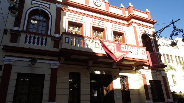 Fachada de un ayuntamiento con balcones y banderas