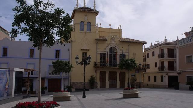 Plaza con un edificio histórico de fachada amarilla
