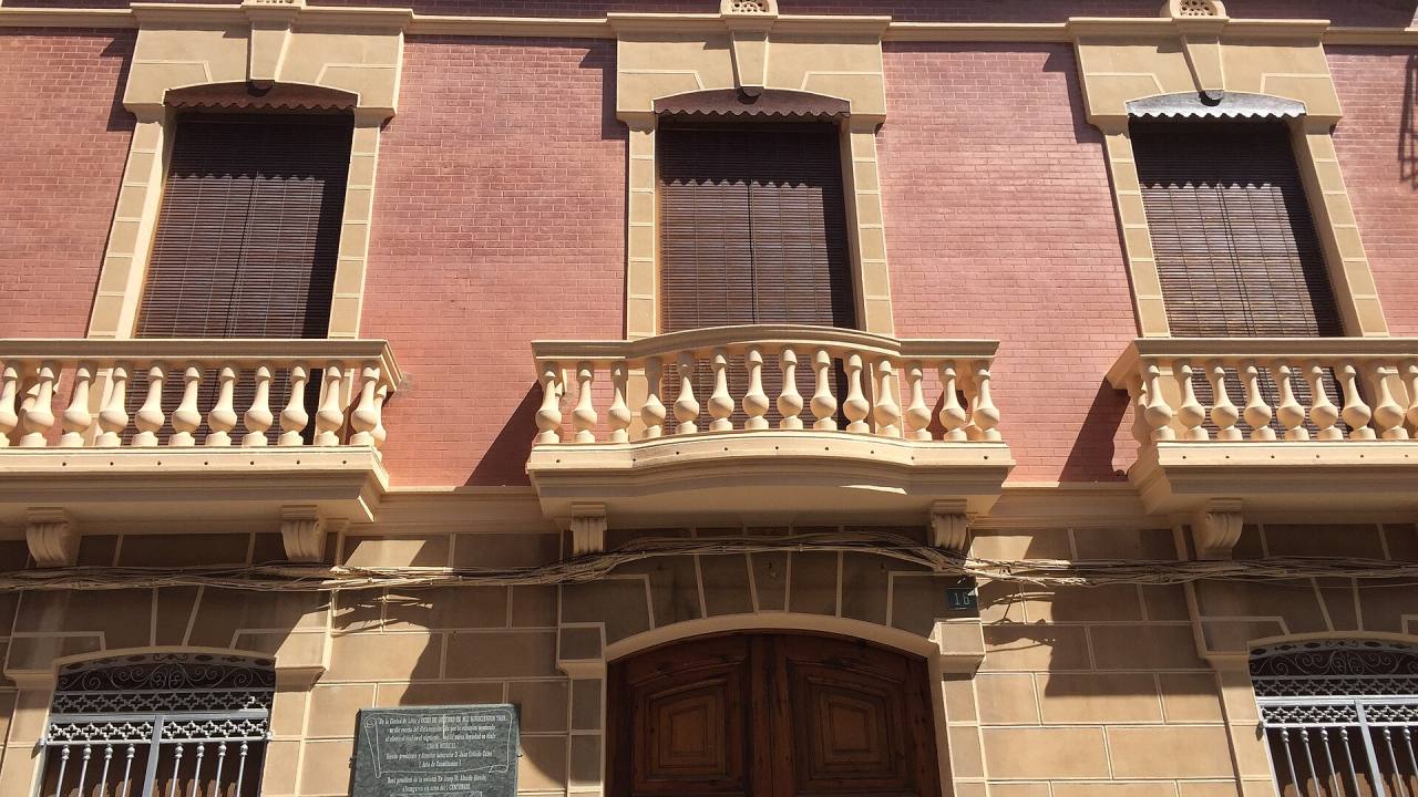 Fachada de un edificio señorial con balcones de piedra en Llíria